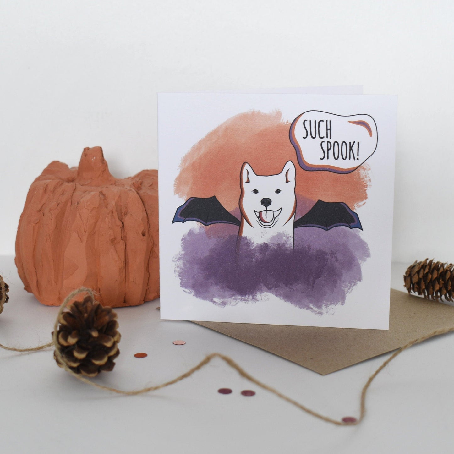 Halloween-themed greeting card with a dog wearing a bat costume and 'Such Spook!' text, surrounded by pumpkins and pinecones.