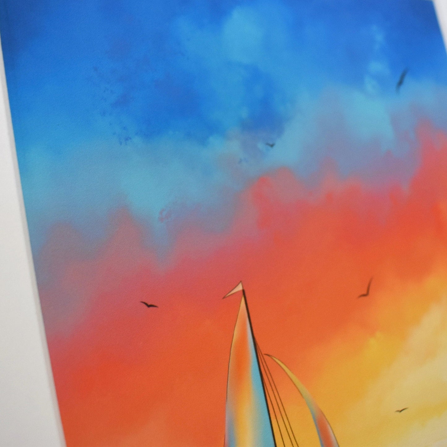 Sailboat painting with a colorful sky transitioning from blue to orange.