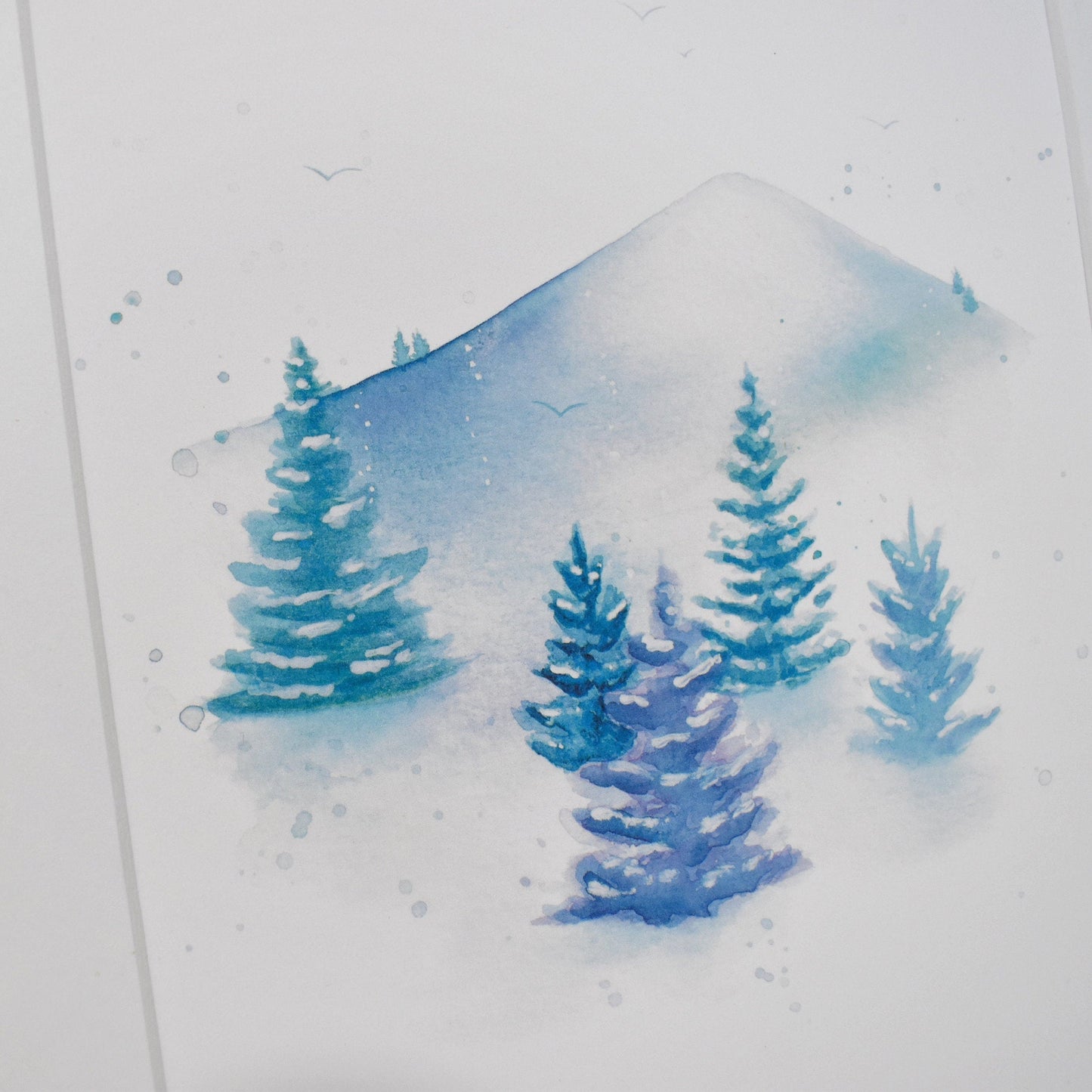 Framed watercolor painting of a snowy landscape with trees
