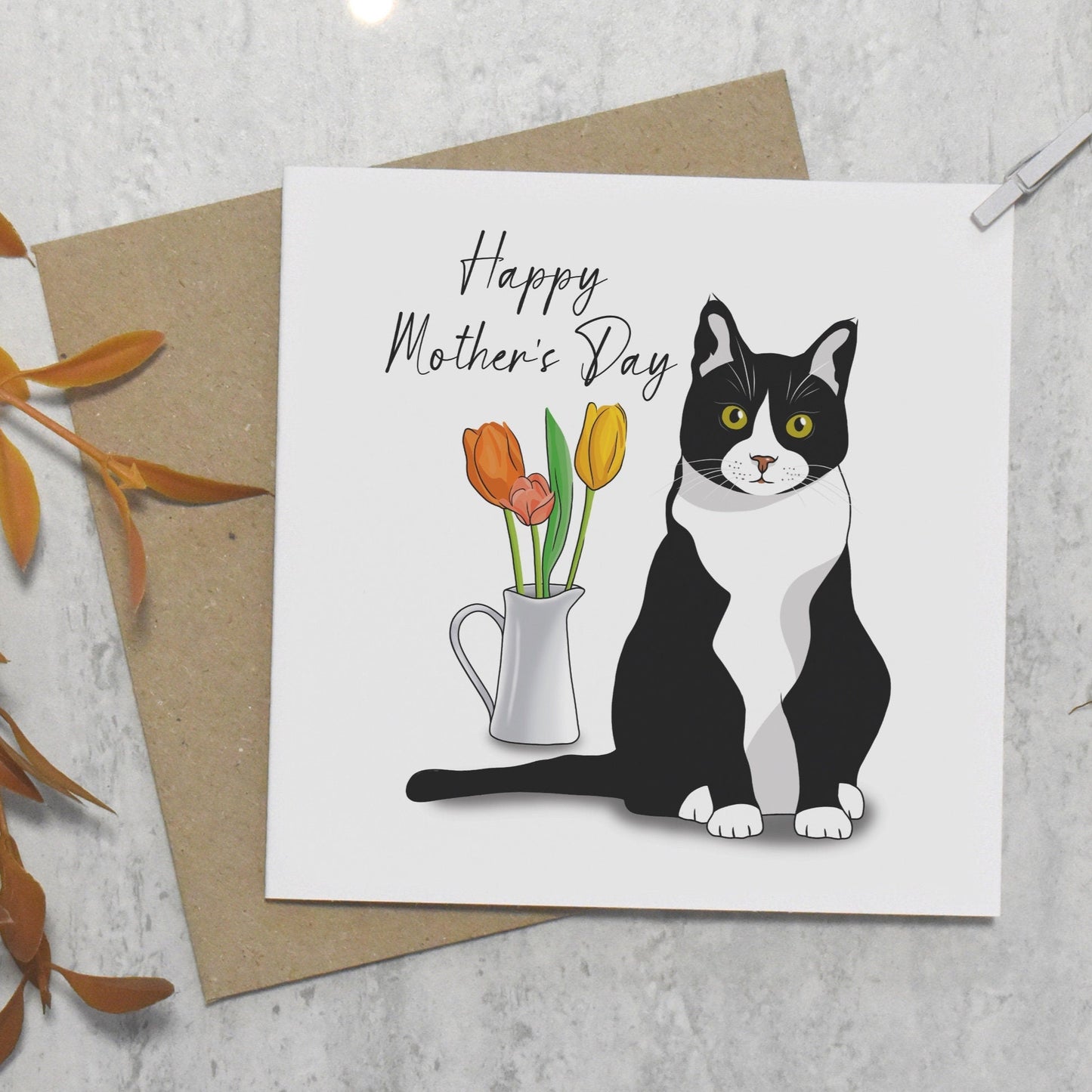 Mother's Day card with a black and white cat illustration and flowers, on a textured surface.