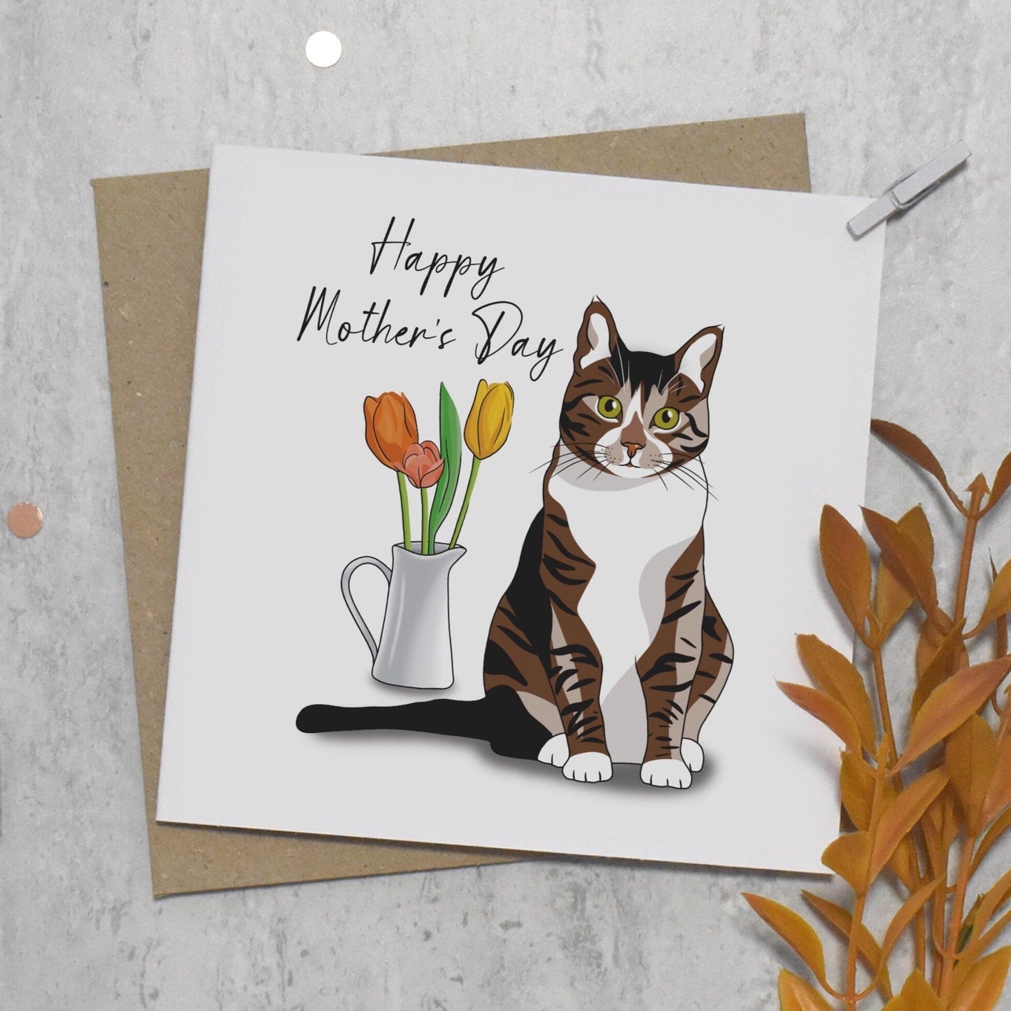 Mother's Day card with a cat illustration and flowers on a textured surface.