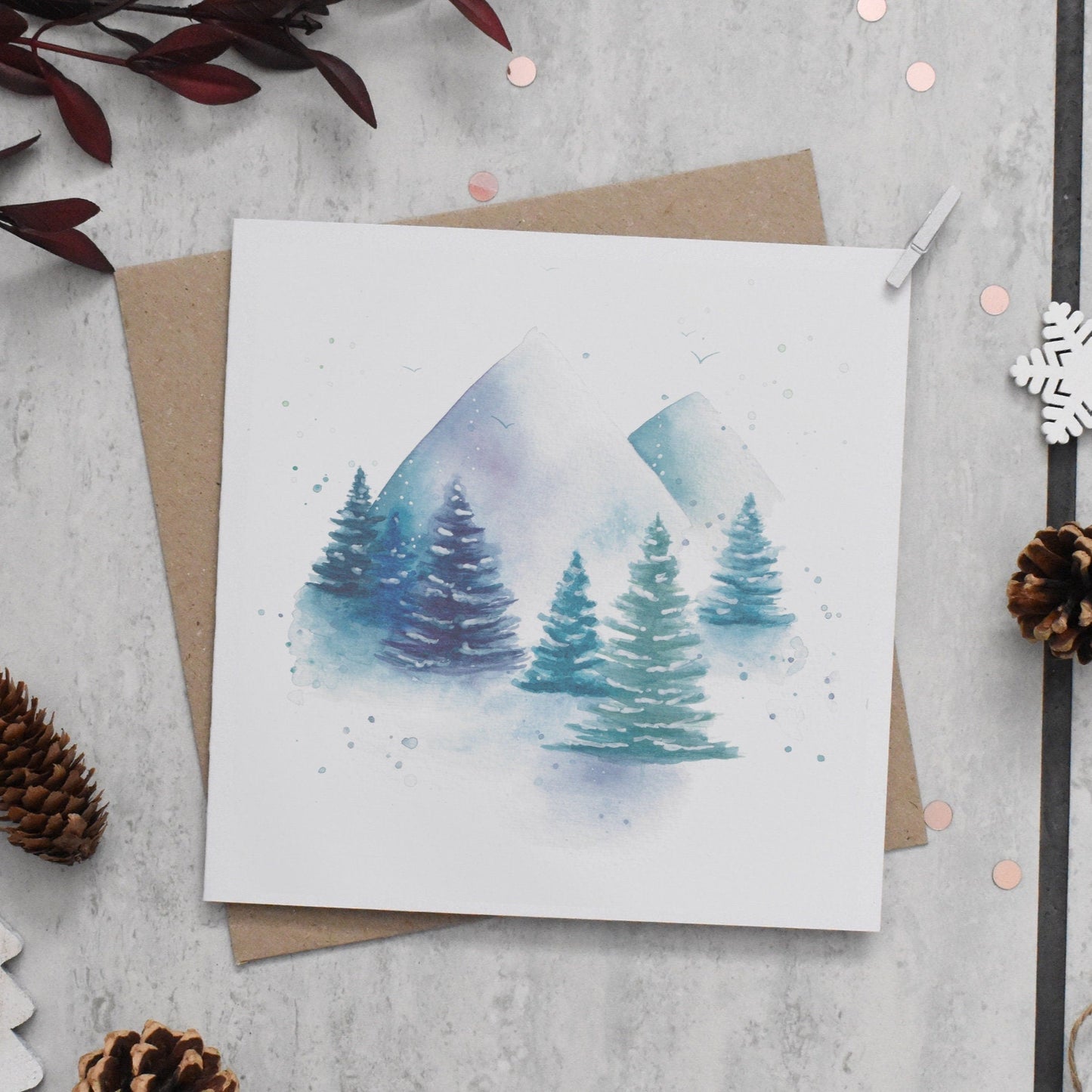 Greeting card with winter scene design on a textured surface with decorative elements.
