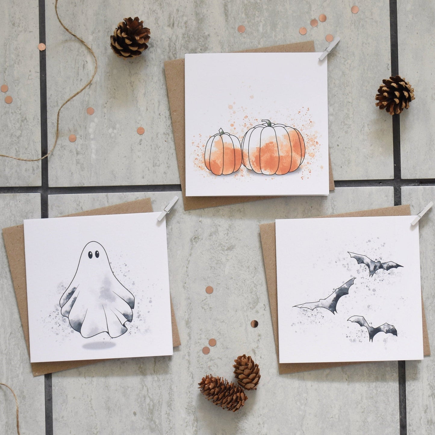 Three Halloween-themed greeting cards on a textured surface with decorative elements.