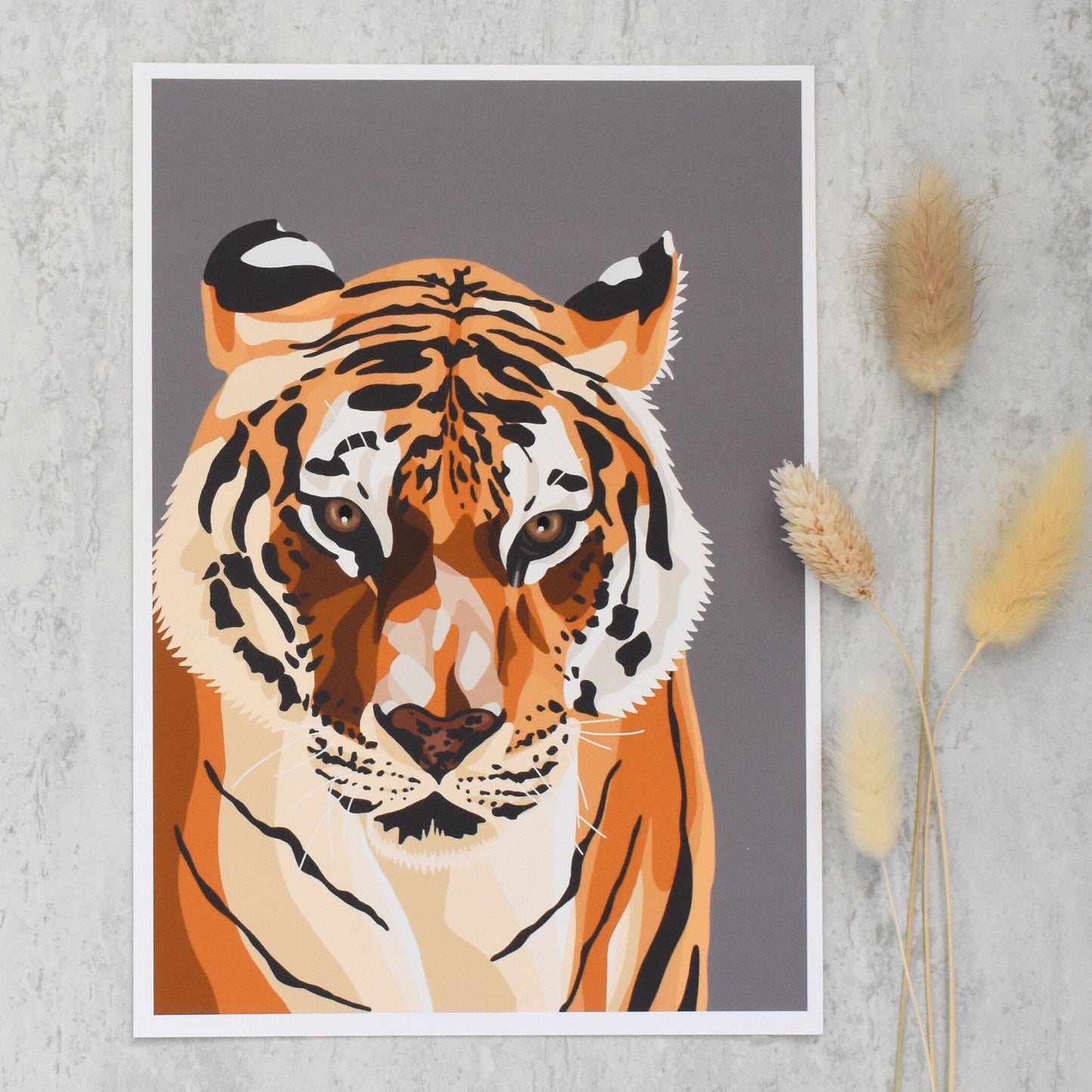 tiger artwork on a textured wall with dried plants.