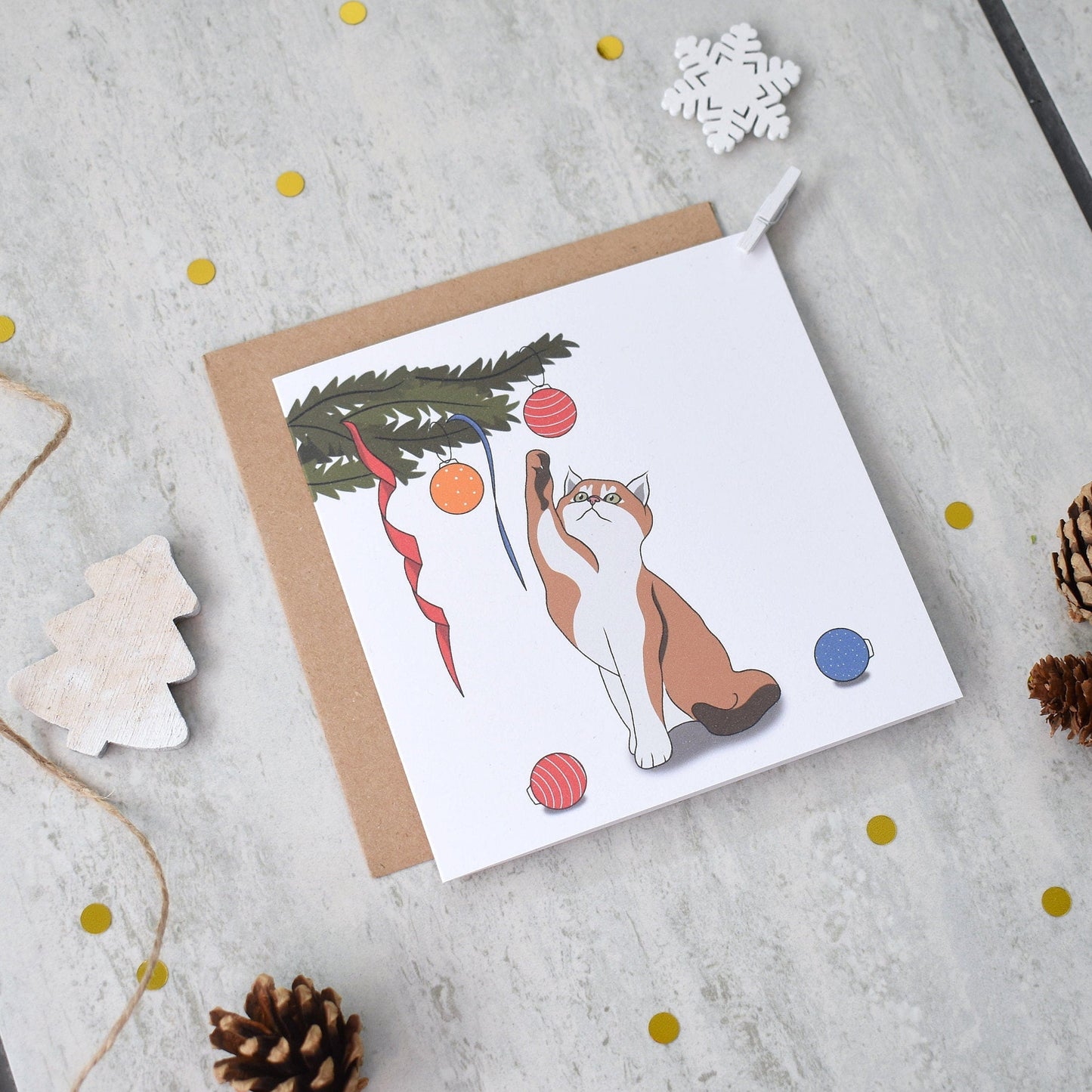 Greeting card with a cat illustration on a textured surface with decorative elements.