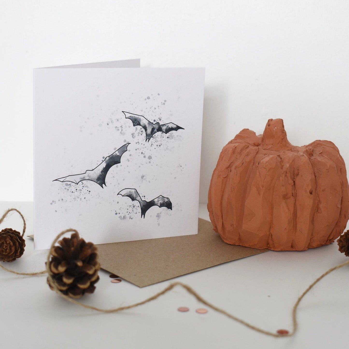 Halloween-themed card with bats and a pumpkin on a white background