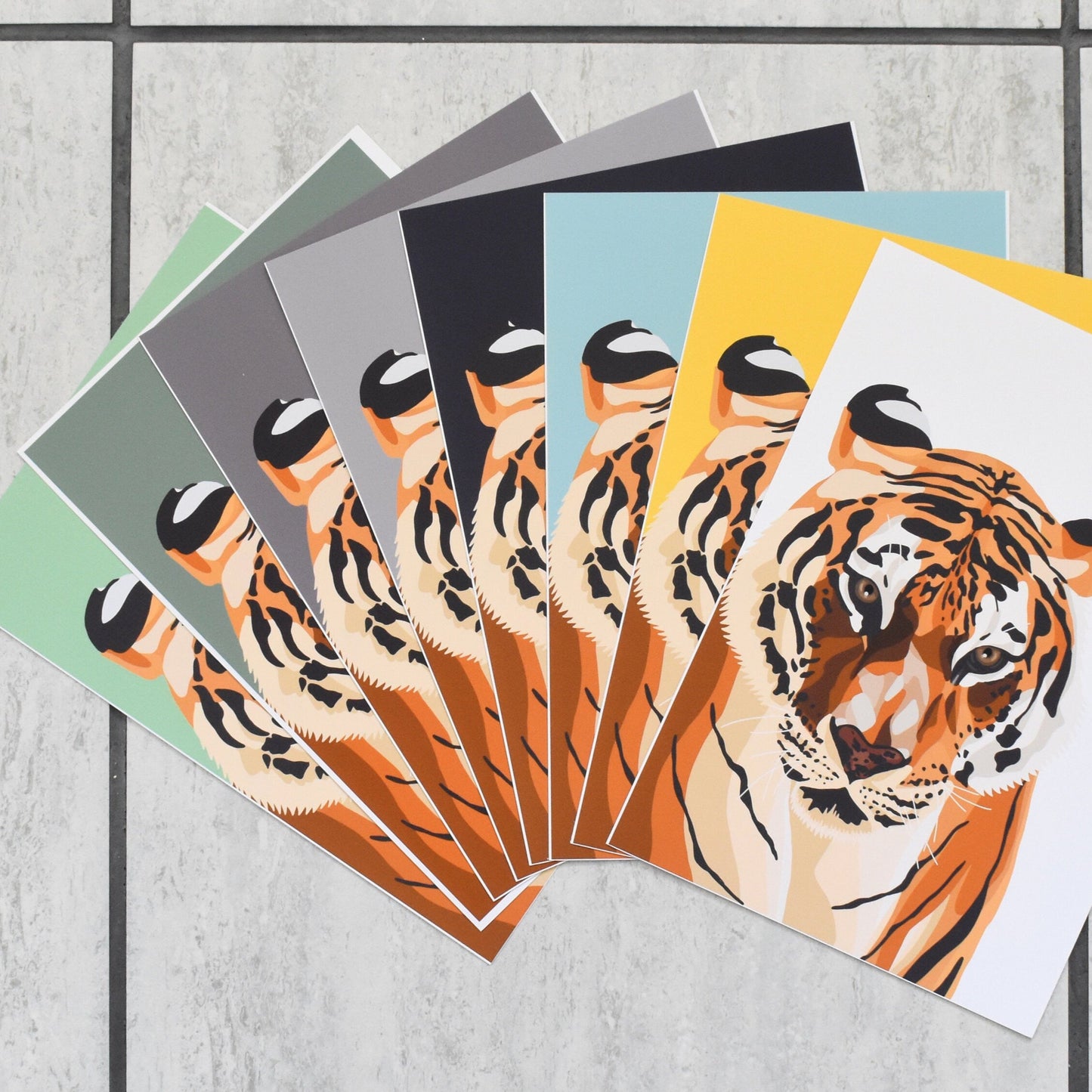 Set of prints with tiger designs on a gray surface