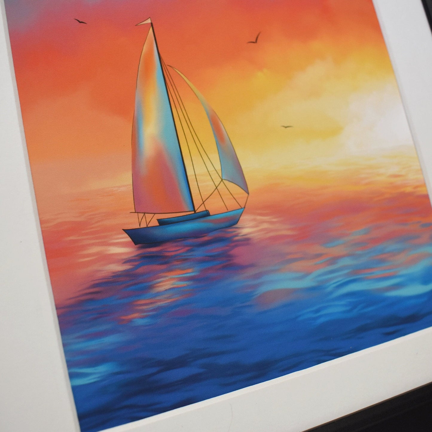 Framed painting of a sailboat on water with a sunset background