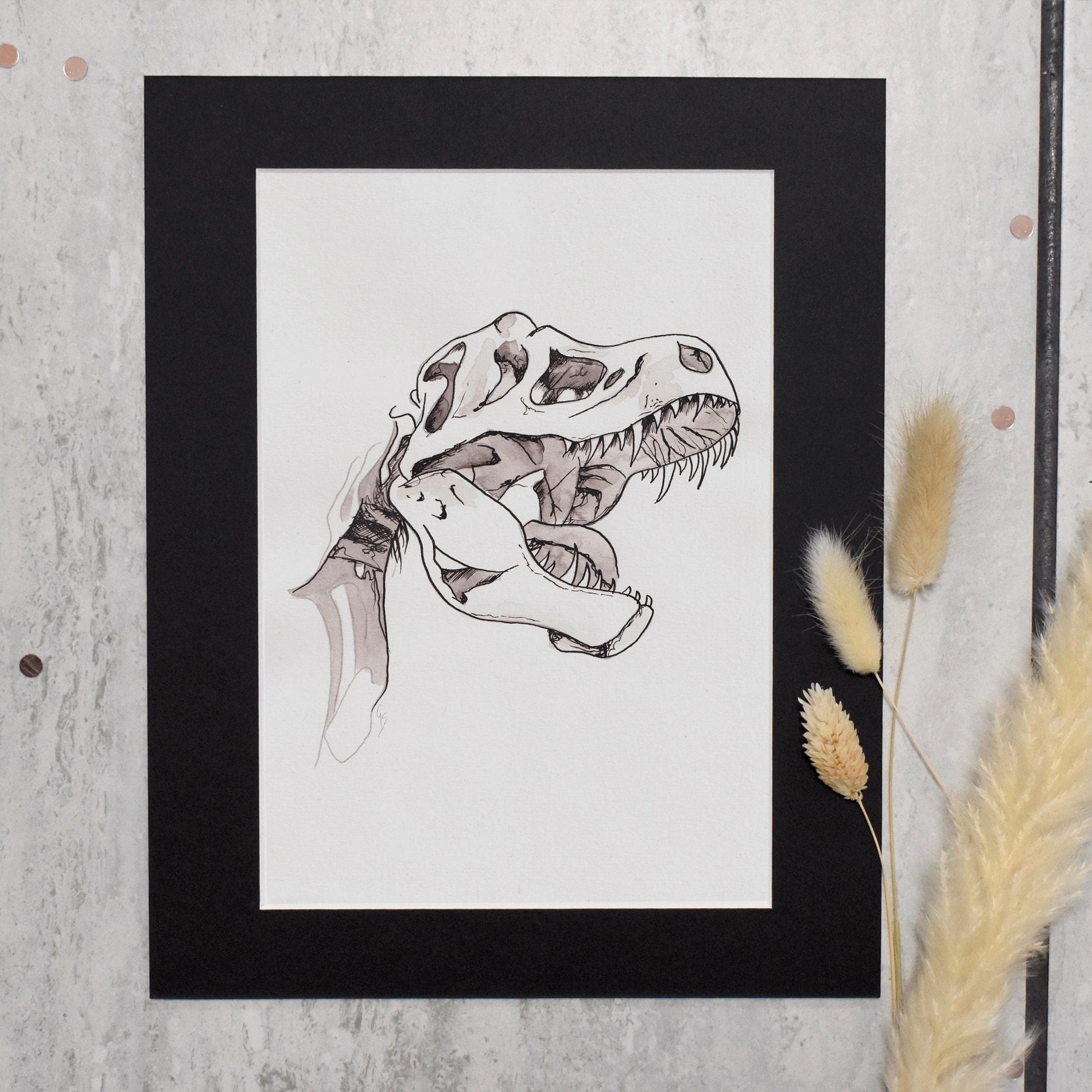 Framed artwork of a dinosaur skeleton on a textured wall with pampas grass.