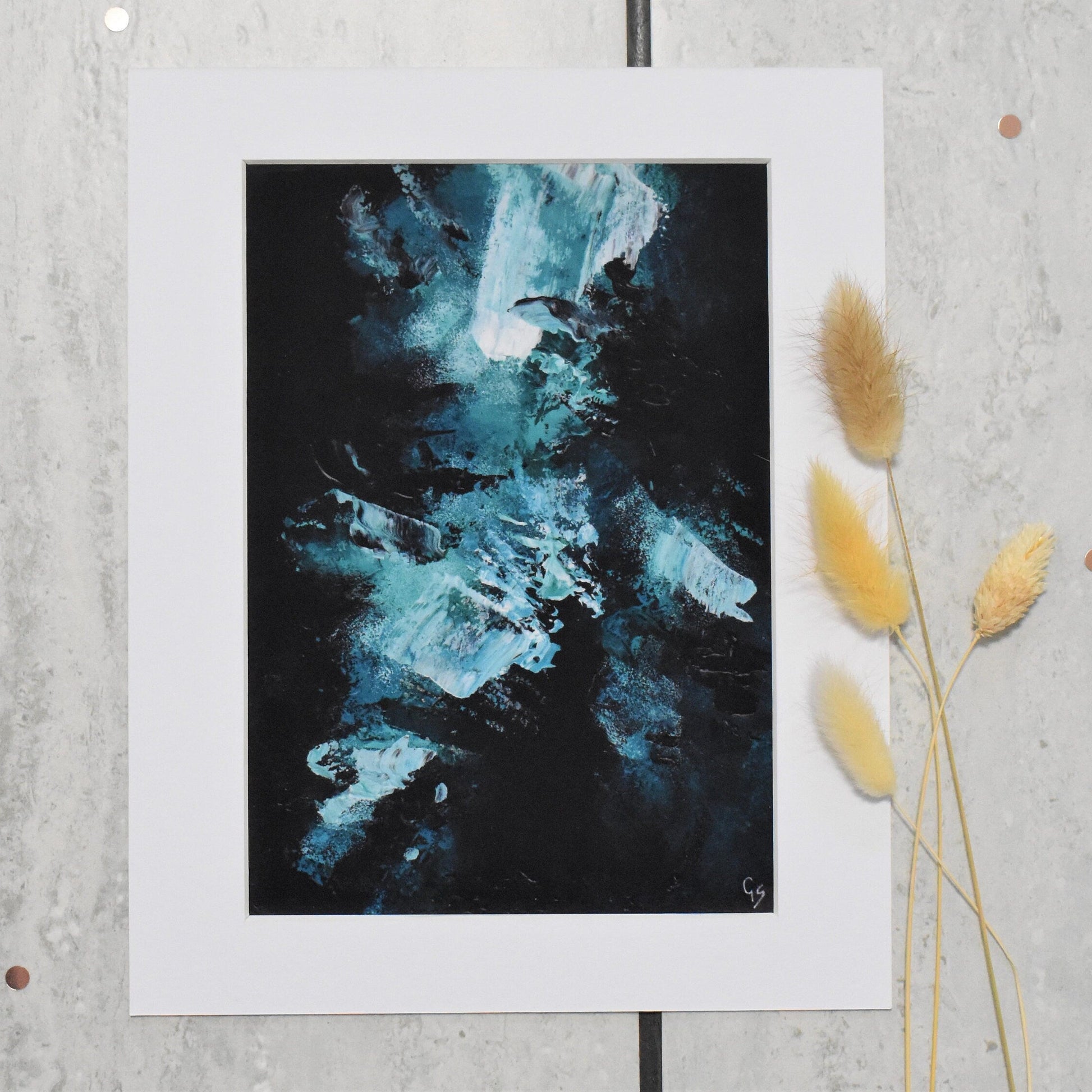 Abstract artwork in a white frame on a textured wall with decorative elements.
