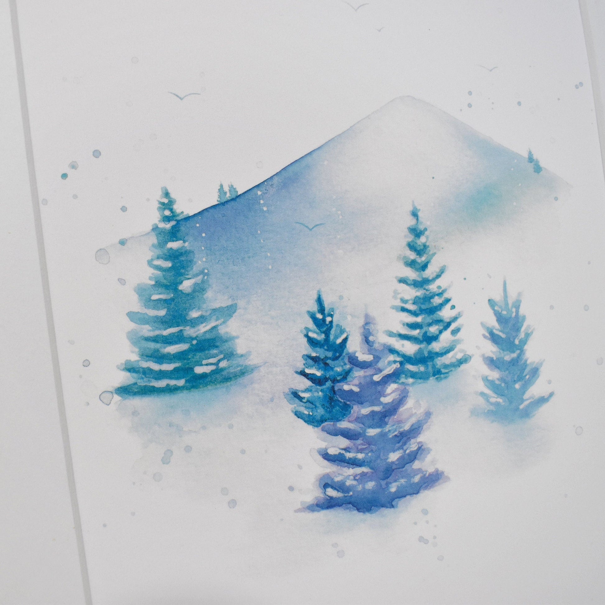 Framed watercolor painting of a snowy landscape with trees