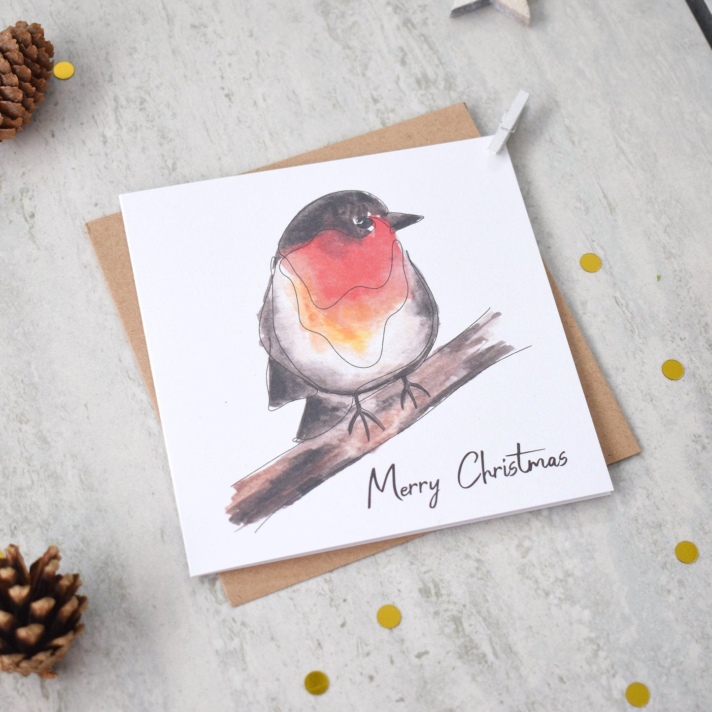 Christmas card with a robin illustration and 'Merry Christmas' text, surrounded by pine cones and snowflakes on a light background.