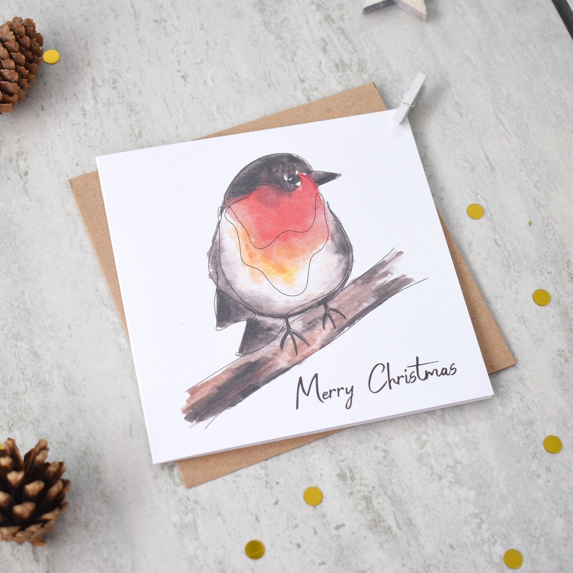 Christmas card with a robin illustration and 'Merry Christmas' text, surrounded by pine cones and snowflakes on a light background.