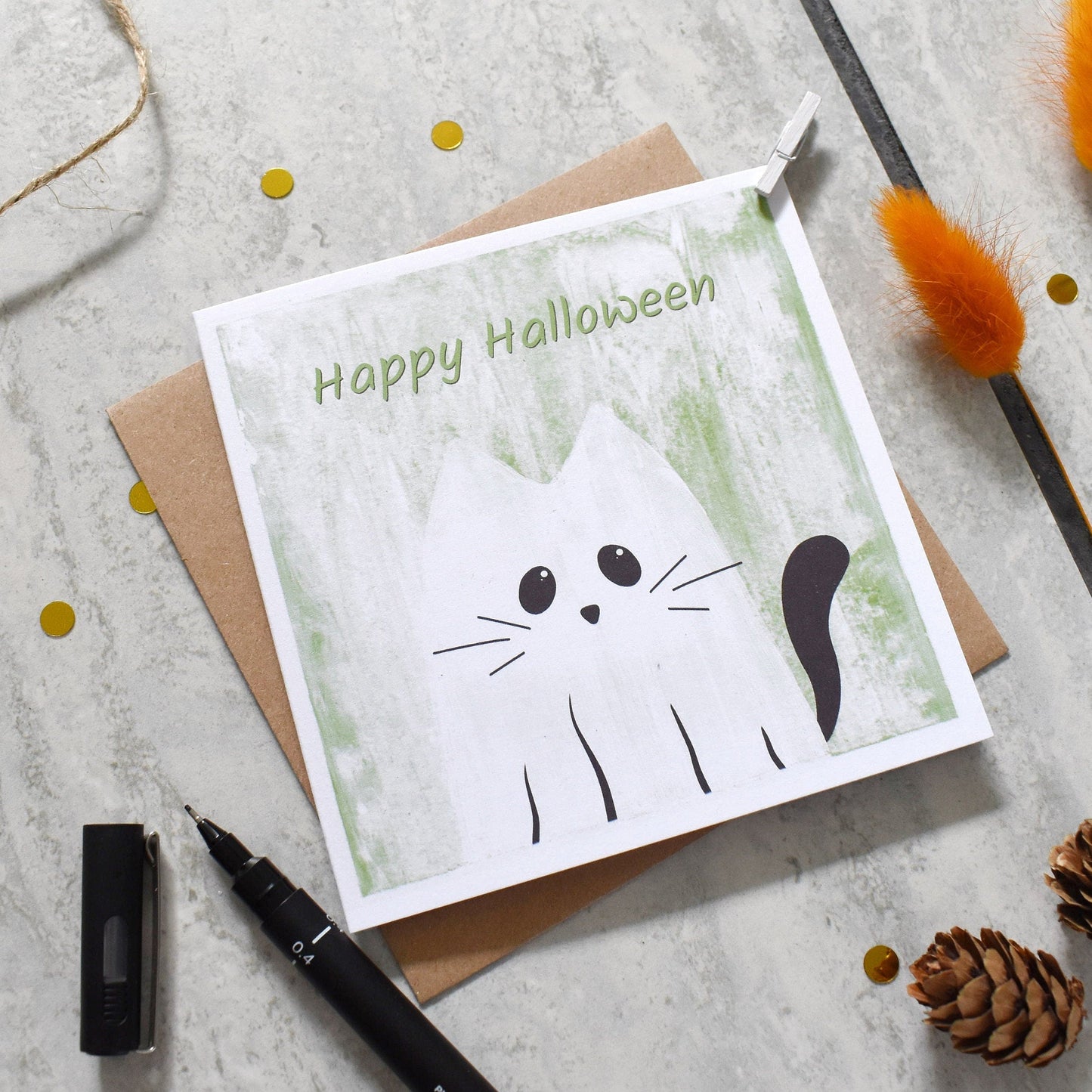 Halloween card with a cat illustration on a textured surface with decorative elements.