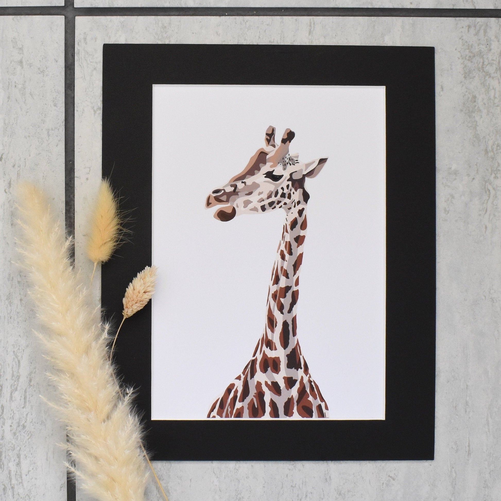 Framed artwork of a giraffe on a textured wall with pampas grass.