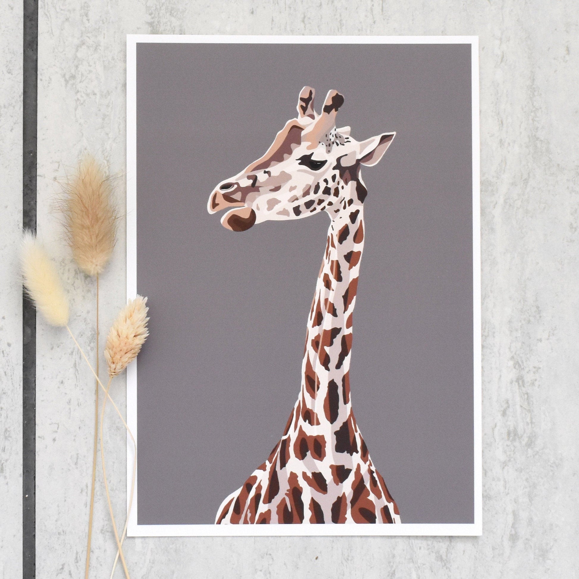 Framed artwork of a giraffe on a gray wall with decorative elements.